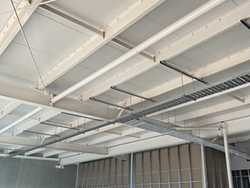 Suspended cable tray installed under steel roof beams in a commercial fitout