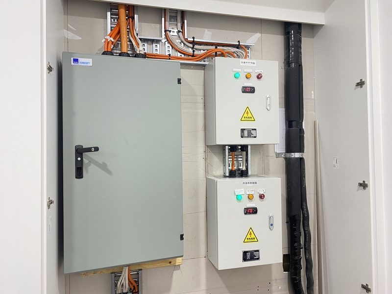 Industrial-grade control cabinets with orange power cables and status indicators