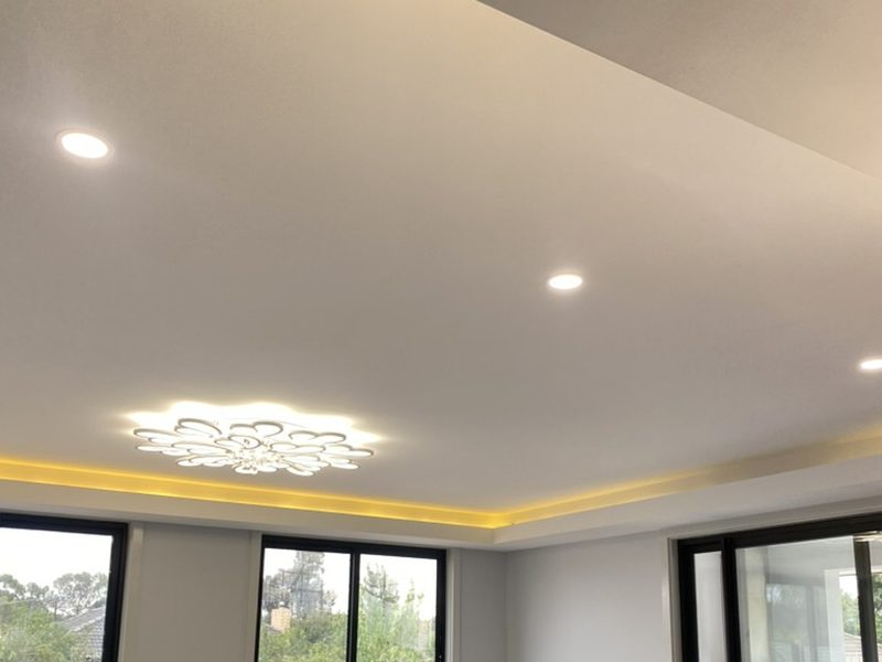 Living room with layered ceiling LED and integrated lighting control