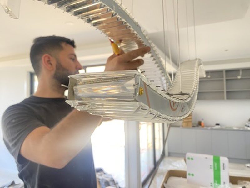 Better Home Technology electrician installing a custom curved chandelier